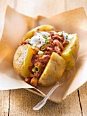 Baked potato garnished with chili con carne