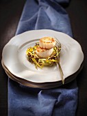Grilled scallops on a bed of thinly sliced leeks
