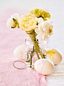 Osterdeko mit Ostereiern und Blumensträußchen