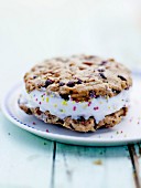Pecan and chocolate chip cookie sandwich with frozen yoghurt and sugar pearls
