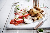 Roast chicken with beer served with caprese salad