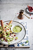 Skewers with Merguez sausages, wheat grass with pomegranate seeds, cheese and pesto