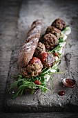 Wholemeal baguette with meatballs, ketchup, rocket and cheese