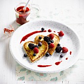 Heart-shaped pancakes with summer berries and coulis