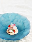 Transparent wild strawberry jelly with fresh coconut and melon cream with edible geraniums