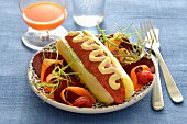 Vegetarischer Hot-Dog mit Gurke, pürierten Tomaten und Guacamole