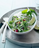 Salat mit Reisnudeln, grünen Bohnen, Rucola, roten Pfefferschoten und Limette