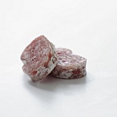 Slices of dried sausage on a white background