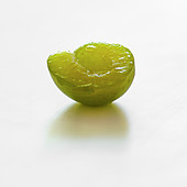 Half a greengage plum on a white background