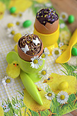 Dunkles und helles Schokoladenosterei im Eierbecher