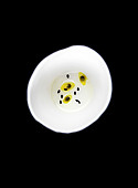 Passion fruit seeds and black sesame seeds in golden sesame seed oil