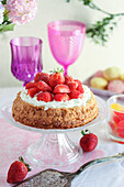 Nest-shaped dessert cake with cream and strawberries