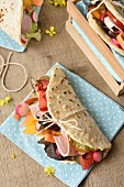 Tomato pineapple, pink radish, thinly stripped carrot and boiled ham Piadina for a picnic