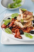 Chicken fillets with coppa, cherry tomatoes, olives, beetroot sprouts and basil