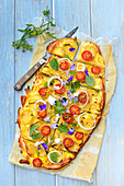 Tart with tomatoes, potatoes and edible flowers