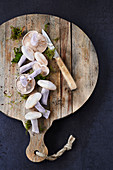 Blue foot mushrooms and moss on a chopping board