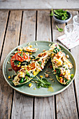 Courgettes and tomatoes stuffed with orzo, halloumi, sweetcorn, chickpeas and spinach