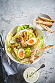 Cäsarsalat mit gekochten Eiern, Brotsticks und Dressing