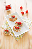 Tuna paté on sliced baguette garnished with lemon, chives and grilled red pepper