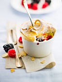 Stewed summer fruit meringue puddings with thinly sliced almonds