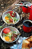 Tin plat of fried egg and tomatoes, cup of coffee for a picnic