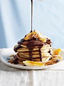 Pancakes with caramelized bananas, chocolate sauce and coconut flakes