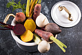 Autumn-winter vegetables in a cooking pot on a black background