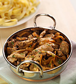 Thinly sliced beef with onions and button mushrooms