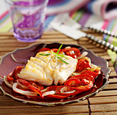 Piece of cod with onions and peppers with paprika