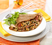 Buckwheat galette garnished with raw ham and mushrooms