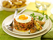 Tartare-style tuna topped with a fried egg, pan-fried potatoes with thyme