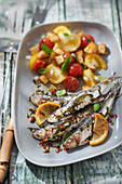 Gegrillte Sardinen mit Kräutern, Salat mit roten und gelben Tomaten