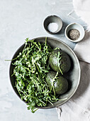 Rocket, avocado, salt and pepper in small bowls
