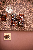 Mehrere Stücke Schokoladenkuchen mit Schokoglasur und silbernen Zuckerperlen