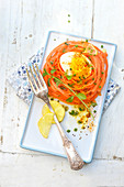 Mimosa egg with Espelette pepper in a nest of grated carrots