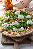 Pizza mit Rucola, Kirschtomaten und Mozzarella