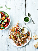 Roasted scampi with herbs and lemons served with cherry tomato salad with mini cucumbers