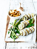 Skrei and lime brochettes with rosemary, pan-fried asparagus, sweet peas and spring onions