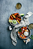 Sweet potato chips with guacamole-coriander and garlic-flavored parmesan cream with pepper