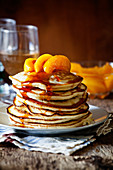 Stapel hausgemachte Pancakes mit pochierten Pfirsichen