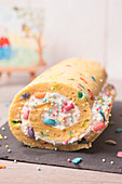 Rolled sponge cake with cream and colored sugar filling