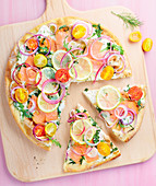 weiße Pizza mit Lachs, Kirschtomaten, Zitrone und Rucola