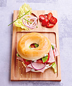 Bagel with roast pork and raw vegetables