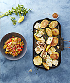 Grilled squid and potatoes served with garlic tomato salad with herbs