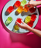 Woman arranging multicolored jellies on a dish