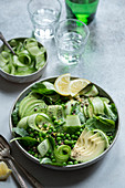 Grüner Salat mit Puylinsen, Erbsen, Gurken, Avocado und Spinat
