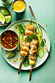 Thai chicken skewers on cucumber strips with chilli sauce