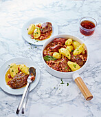 Casserole with pork cheeks and potatoes