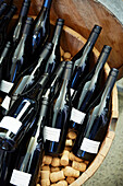 Red wine bottles in wooden barrel with cork