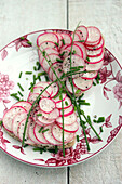 Heart-shaped toast with radishes, cream cheese and chives